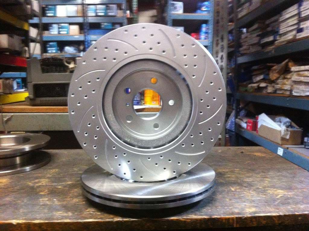 Custom drilled brake rotor displayed on a workbench inside ACR Auto Parts